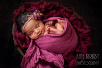 sleeping newborn wrapped in pink